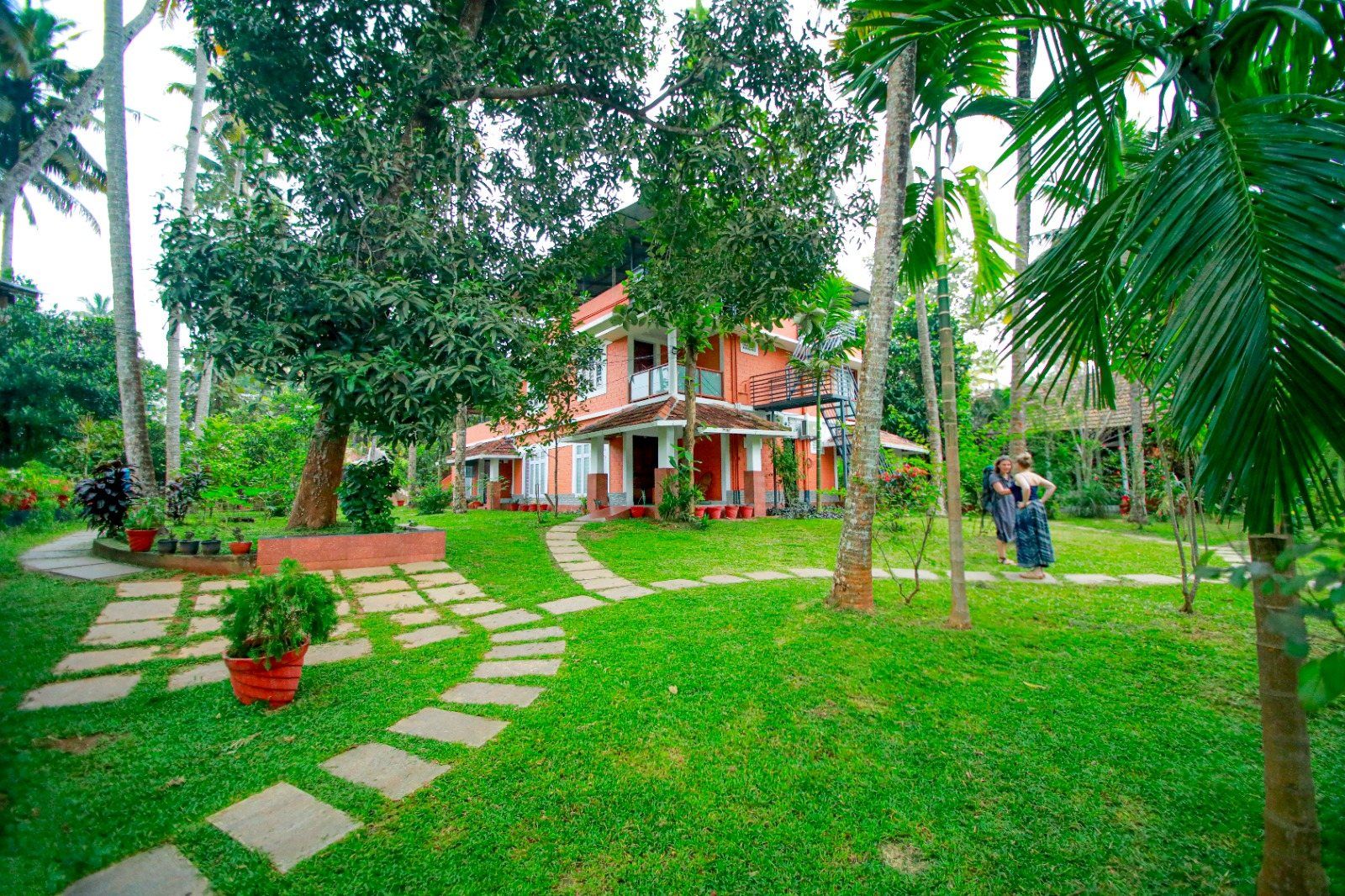 The garden of the Ayurvedic center in Varkala: paths among palms and a two-story building